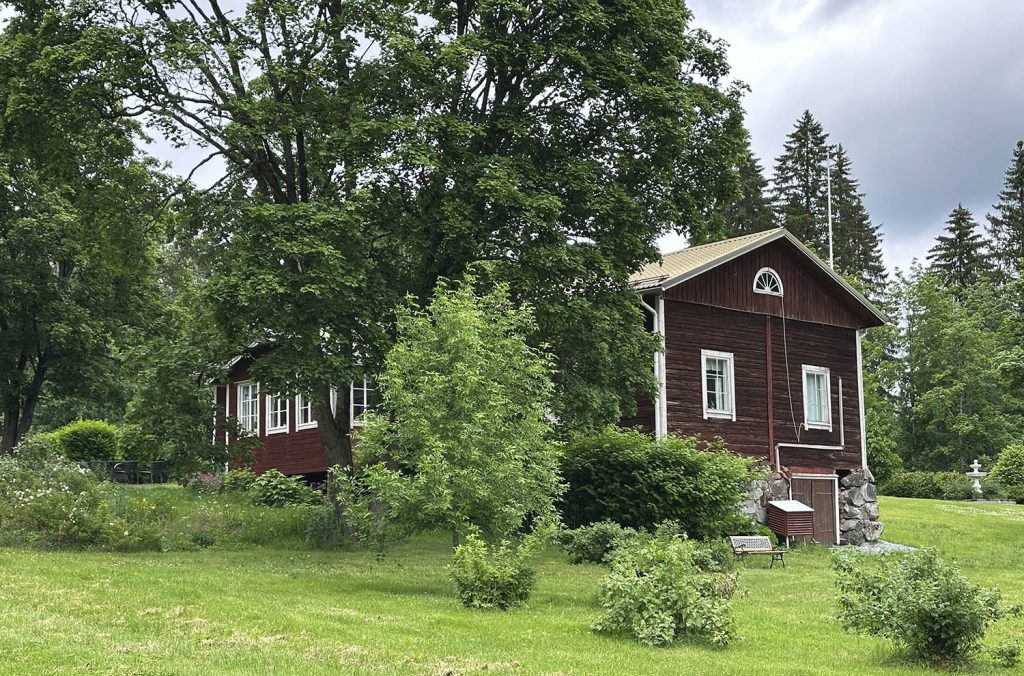 Vehreän vihreä kartanon puutarha ja Pakaritupa.
